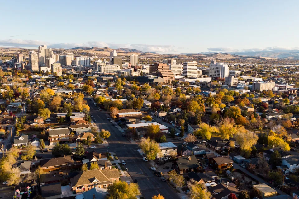 Aerial view of Reno, Nevada with homes in foreground and downtown buildings in background during autumn.